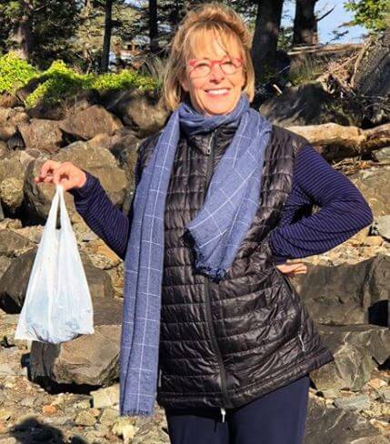 Anne Carver posing with trash in her hand.